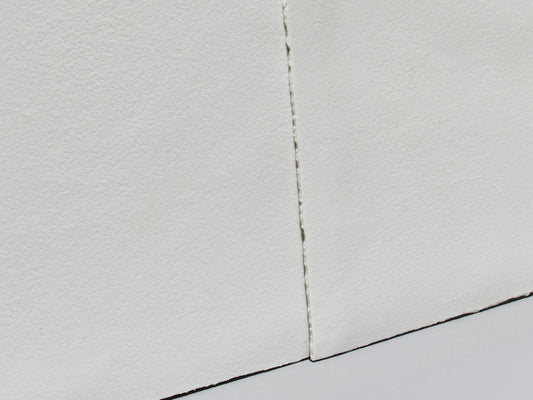 Detailaufnahme zweier unglasierter Porzellanfliesen mit matter, strukturierter Oberfläche und sichtbarem Fugenverlauf.
Detail view of two unglazed porcelain tiles with a matte, textured surface and a visible grout line.