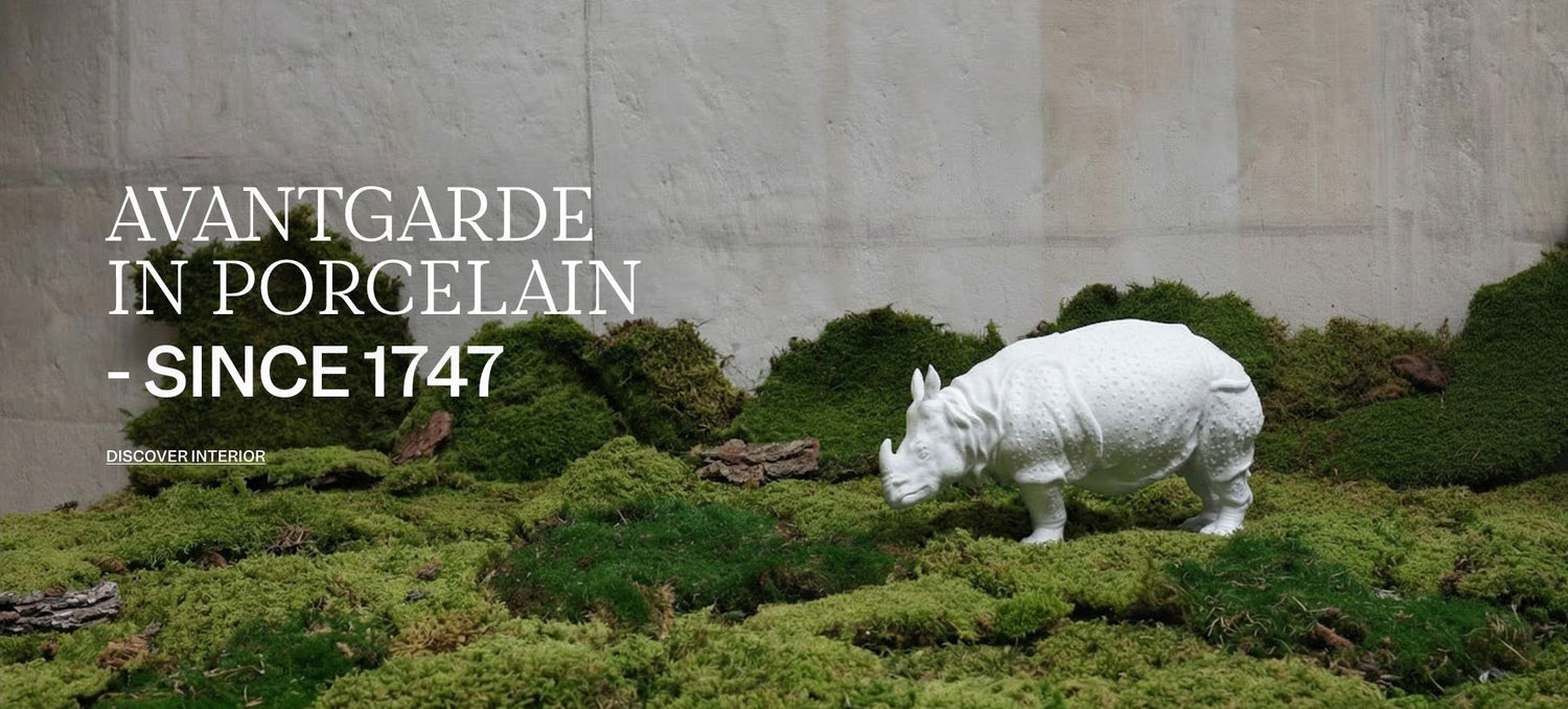 Porzellan-Nashorn von Nymphenburg auf grünem Moosteppich vor heller Wand, links der Schriftzug „Avantgarde in Porzellan – seit 1747“.


White Nymphenburg porcelain rhinoceros on green moss in front of a light wall, with the German headline “Avantgarde in Porzellan – seit 1747” on the left.