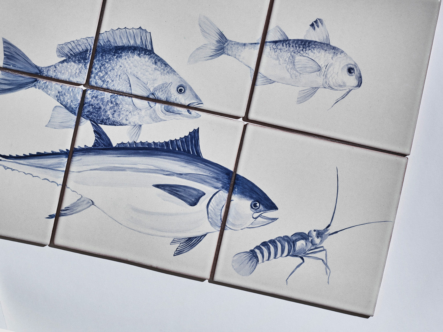 Sechsteiliges Fliesenbild mit handgemalten Meeresmotiven in Blau auf hellem Grund: Fische und ein Krebs.

Six-tile mural with hand-painted marine motifs in blue on a light background: fish and a crustacean.