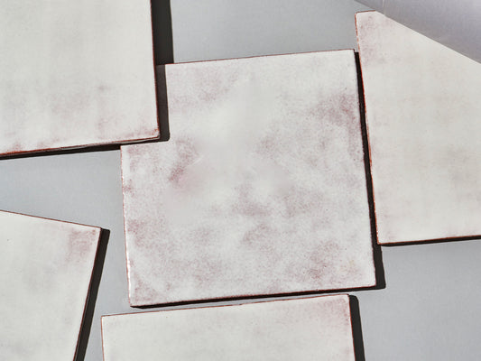 Majolika-Fliese mit durchschimmernder weißer Glasur und changierender Oberfläche.

Majolica tile with translucent white glaze and subtly shifting surface tones